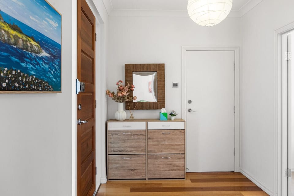 Step inside through the welcoming entrance, where a tidy console and mirror create a practical spot to drop your keys and settle in after a day exploring the neighbourhood.