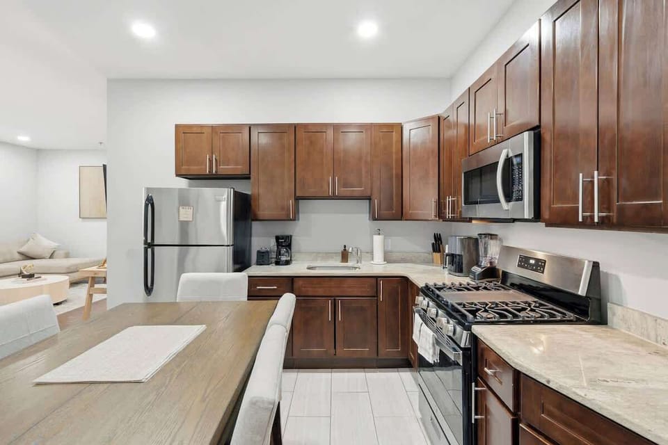 Modern, fully equipped kitchen with stainless steel appliances and a cozy breakfast bar