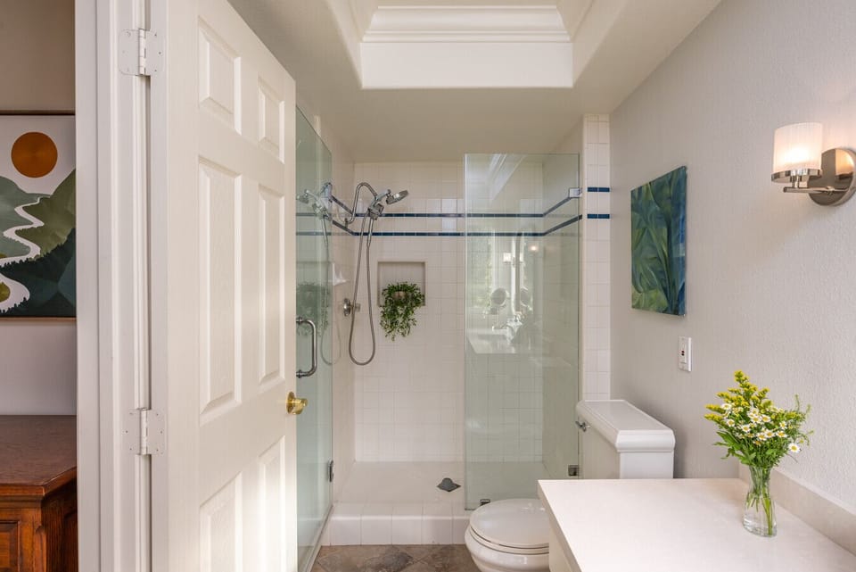 Clean, spacious bathroom with a glass walk-in shower and bright skylight for natural light. A comfortable, practical setup for extended stays and everyday routines.