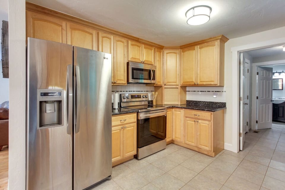 Kitchen | Stainless Steel Appliances, Warm Wood Cabinetry & Open Dining Flow