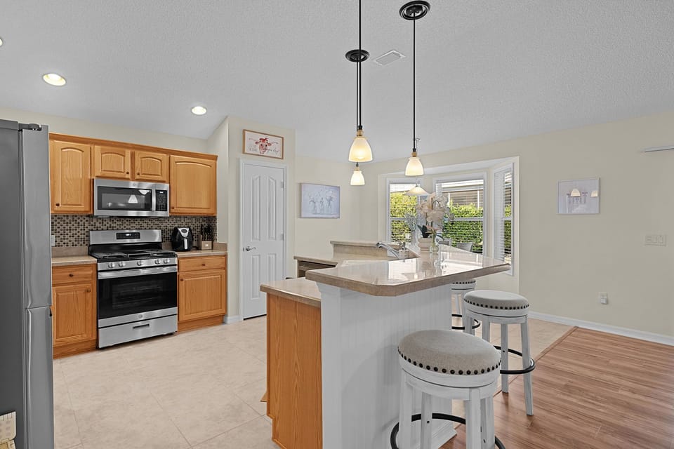 Your fully equipped kitchen features modern appliances and a breakfast bar where you can enjoy morning coffee while natural light streams in.