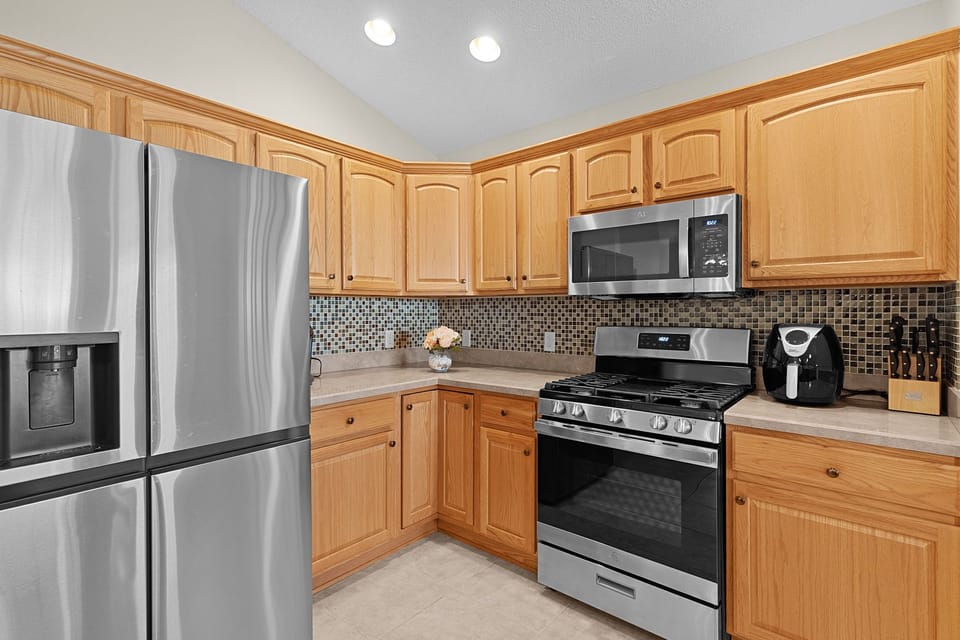 Your fully equipped kitchen features stainless steel appliances, warm wood cabinets, and stylish tile backsplash for all your culinary adventures.