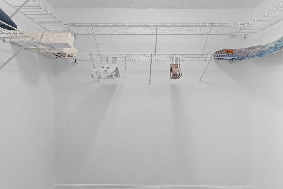 Your spacious walk-in closet features organized wire shelving and hanging space for all your belongings during your stay.