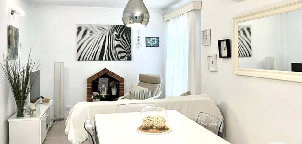 Living-dining area of Apartment Gola, bright and modern, featuring a decorative fireplace, comfortable seating area and integrated dining space.
