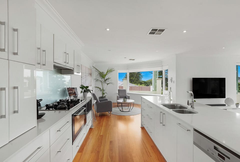 Sleek open-plan kitchen flowing into a bright living area, perfect for cooking and relaxing