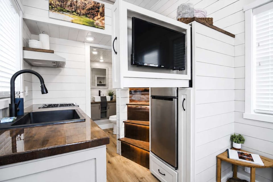 Efficient open-concept living space with a modern kitchen, built-in TV, full-size refrigerator, and smart storage. Thoughtfully designed for comfort while exploring Zion National Park and the best of Southern Utah.