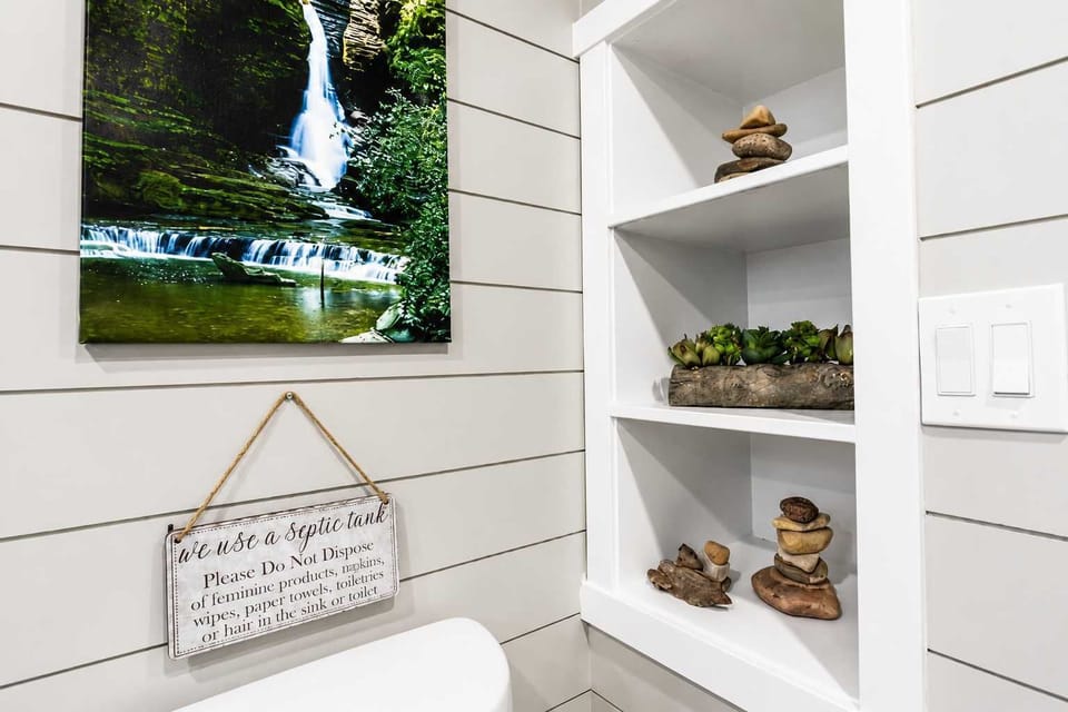 Built-in shelving with fresh towels and thoughtful décor adds convenient storage while giving the bathroom a clean, organized feel.