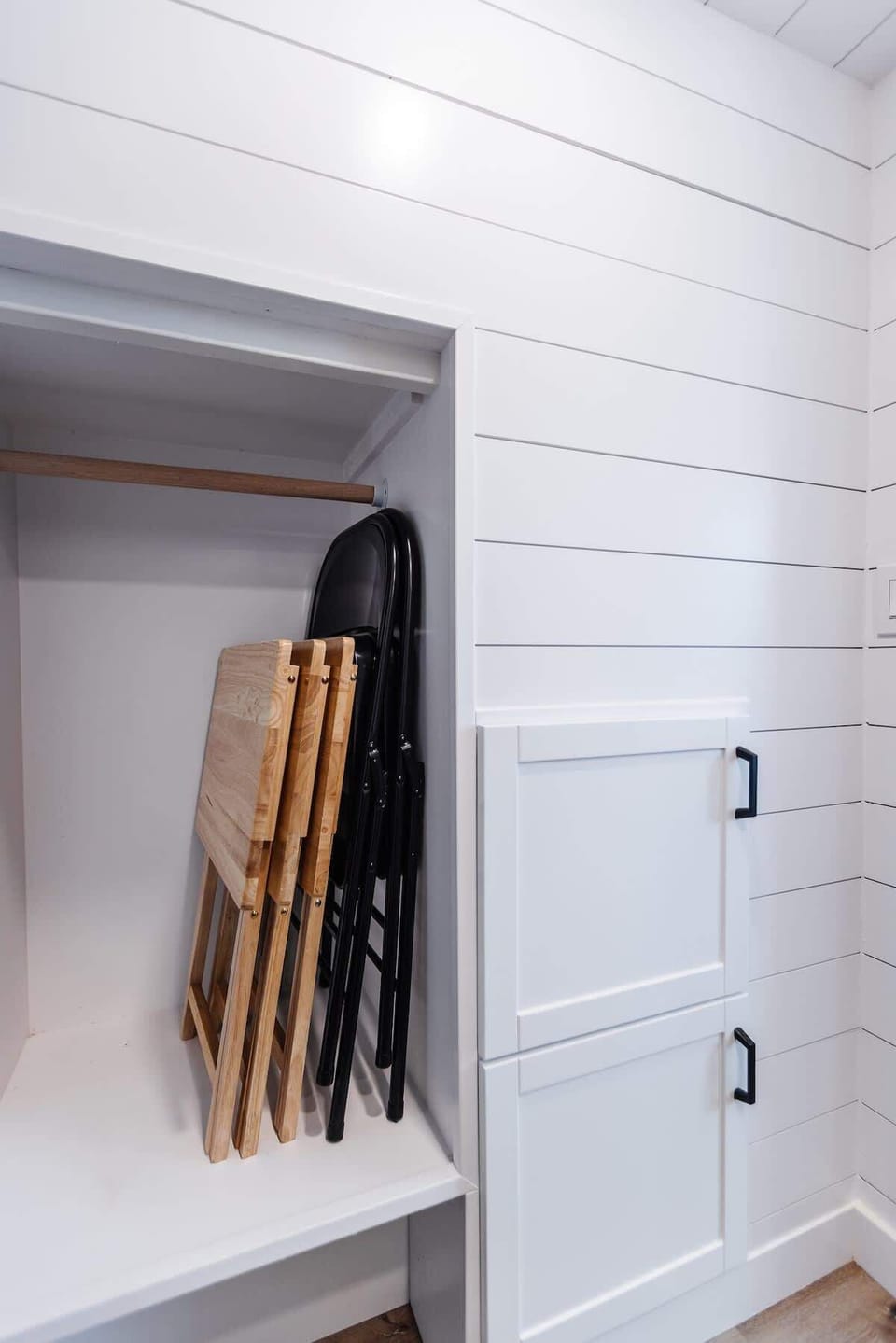 Convenient folding TV trays and chairs provide flexible extra space for dining, working, or relaxing while making the most of the tiny home layout.