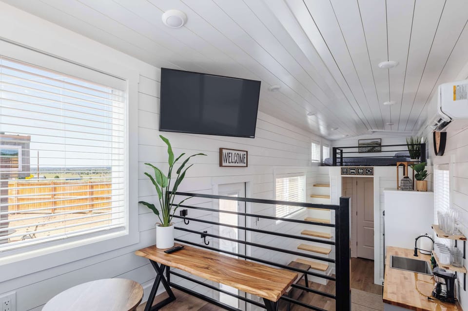 Open-concept loft living space featuring a Smart TV, comfortable seating, and a bright, airy layout designed to maximize every square foot.