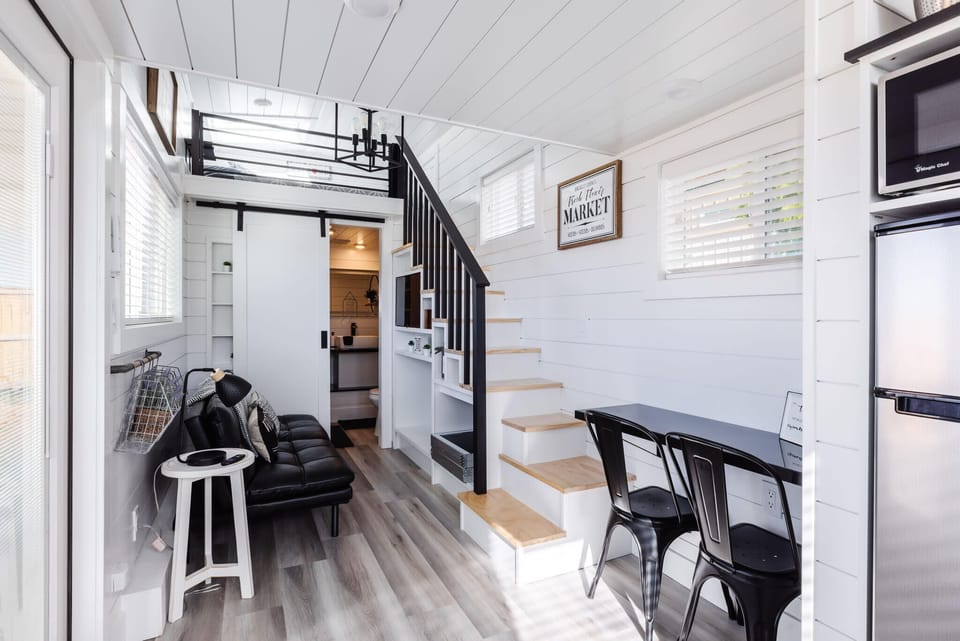 The dining area features a tabletop that maximizes space while providing a cozy spot to enjoy meals. Paired with comfy chairs, it’s the perfect blend of functionality and comfort in a stylish, space-saving design.