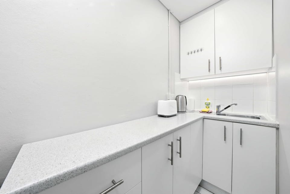 Neat and practical kitchenette with ample cabinetry and counter space.