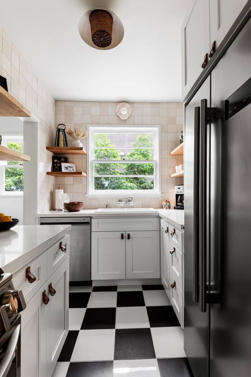 Bright white kitchen with clean lines and a beautiful view of the outdoors.