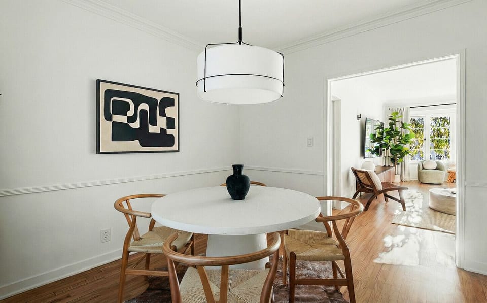 Bright dining area with a sleek white table and modern overhead lights.