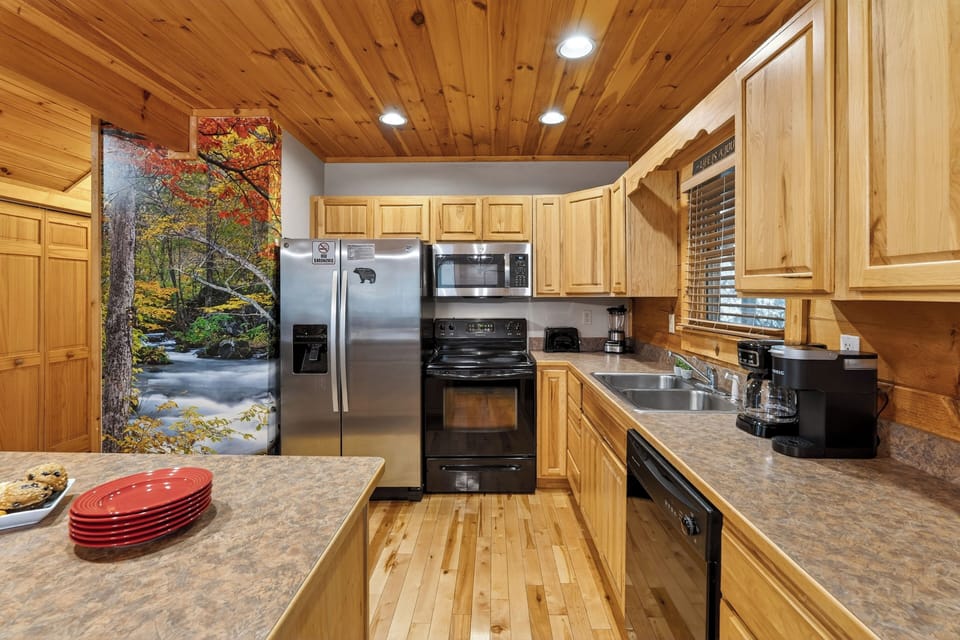 Fully equipped kitchen with stainless steel appliances and wood cabinetry.
