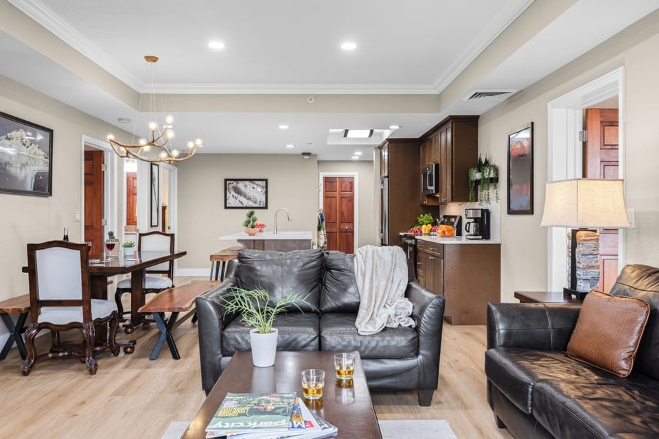 Warm and inviting living room with a stone fireplace, leather seating, and sliding doors leading to a private balcony with mountain views.