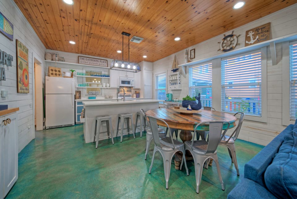 Open-concept dining and living area designed for gathering—natural wood ceilings, coastal décor, and plenty of space to share meals and memories.