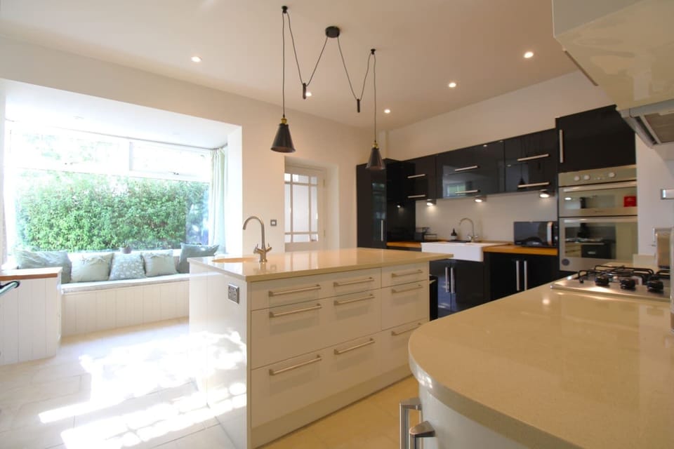 Kitchen island and window seat visible in the distance.