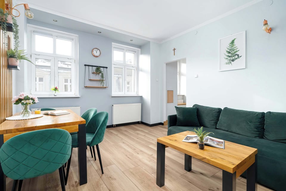 Open space combining green sofa seating with dining table and chairs.