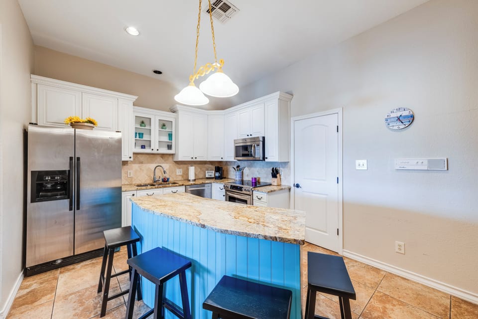 Your fully equipped kitchen features granite countertops, stainless steel appliances, and a breakfast bar perfect for morning coffee or casual meals.