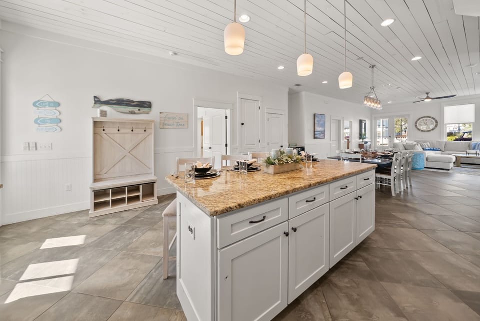 Step into your stunning open kitchen with granite island, coastal touches, and warm pendant lighting perfect for gathering.