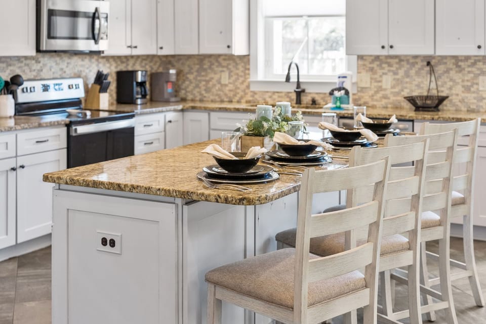 Gather around your spacious kitchen island where granite countertops and crisp white cabinetry create the perfect space for memorable meals together.