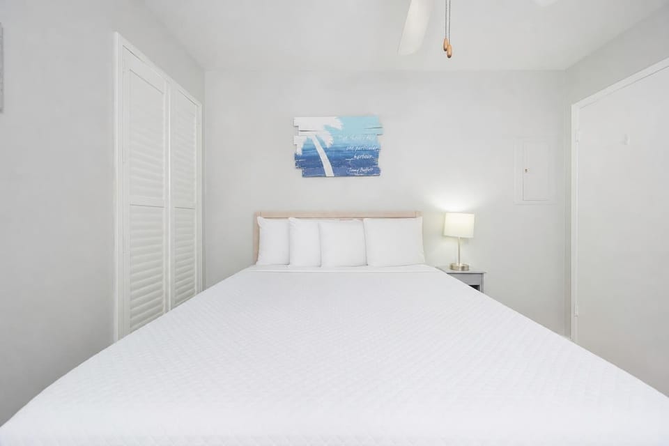 The guest suite invites restful sleep with a soft queen bed and gentle bedside lamp glow