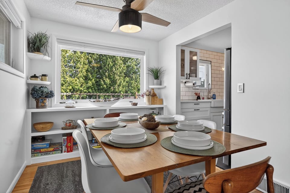Bright dining nook with window views, games, and chic kitchen access