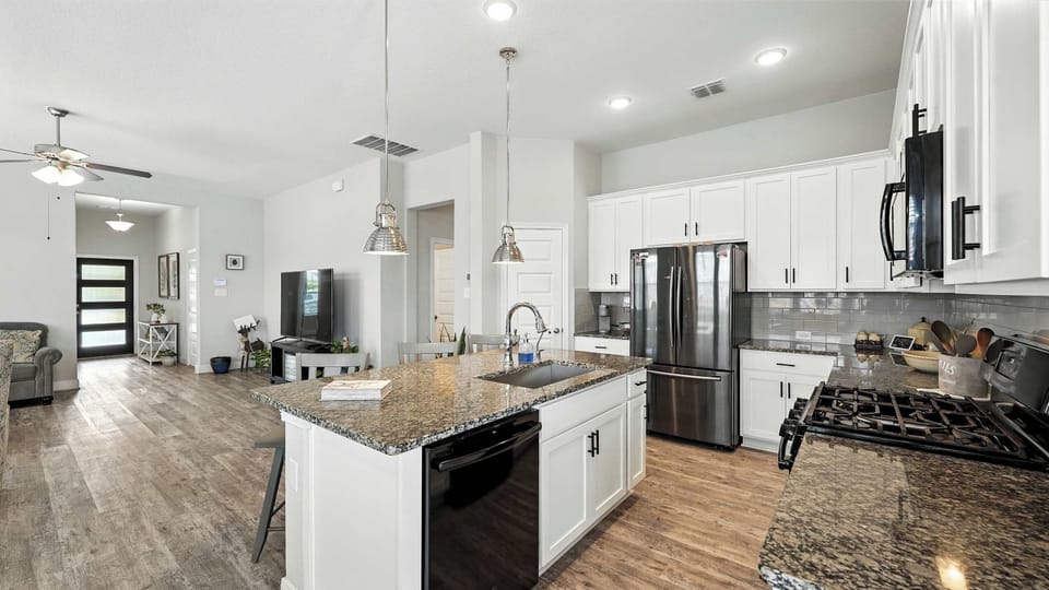 Kitchen view featuring a large granite island with bar seating, ideal for casual dining or working from home.