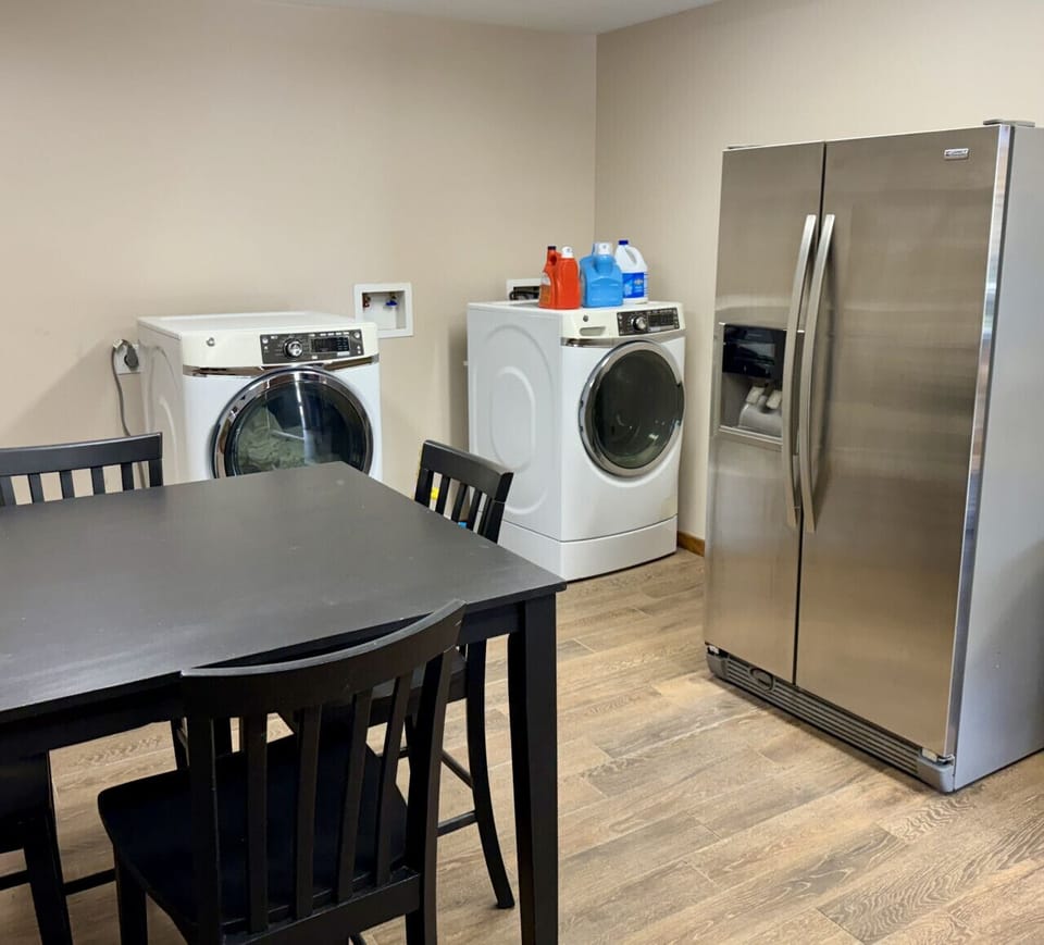 The shared Bungalow Kitchen includes a dedicated dining table, washer and dryer, and folding chairs available for use in the BBQ area.