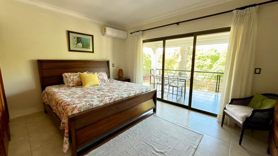 Master bedroom featuring a king-size bed with direct access to peaceful balcony.