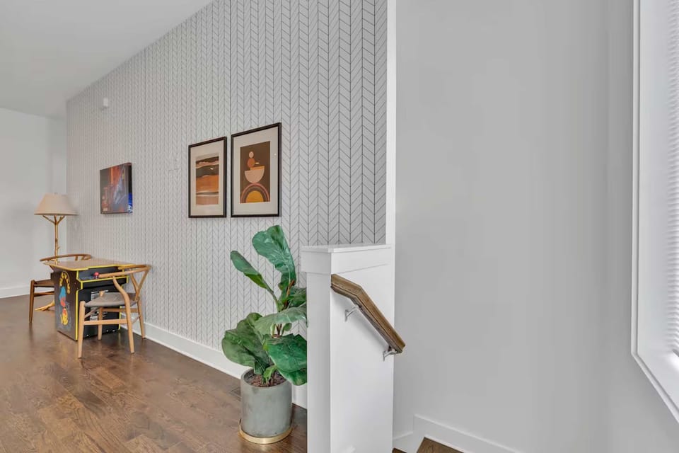 Open-concept living w/Mrs. Pac-Man arcade table, plush seating, and a bright, modern kitchen. | Unit B