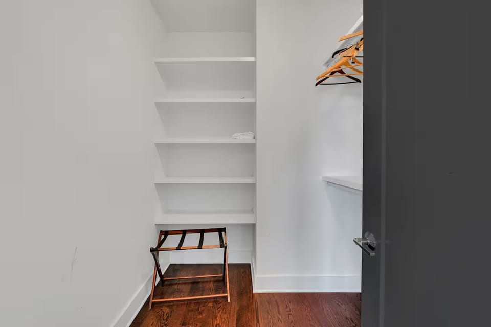Spacious walk-in closet with built-in shelves, ample hangers, and luggage space.