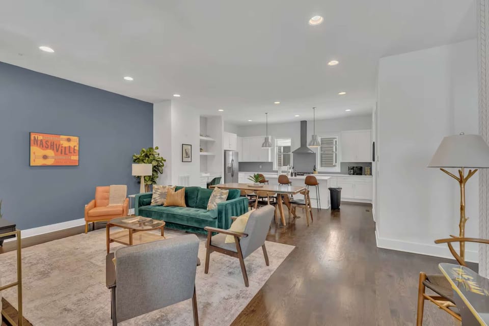 Open-concept living w/Mrs. Pac-Man arcade table, plush seating, and a bright, modern kitchen.