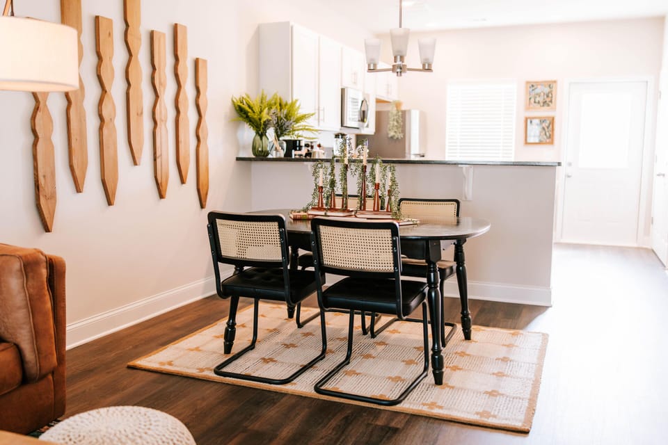 Leather sofa, rattan chairs, and sunlit space for gathering.