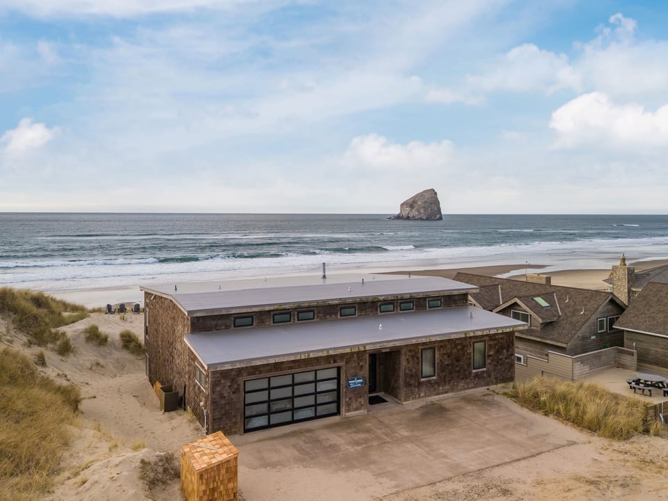 1 Stunning beachfront property offering direct access to pristine sandy shores with dramatic ocean rock formations creating an unforgettable coastal setting.