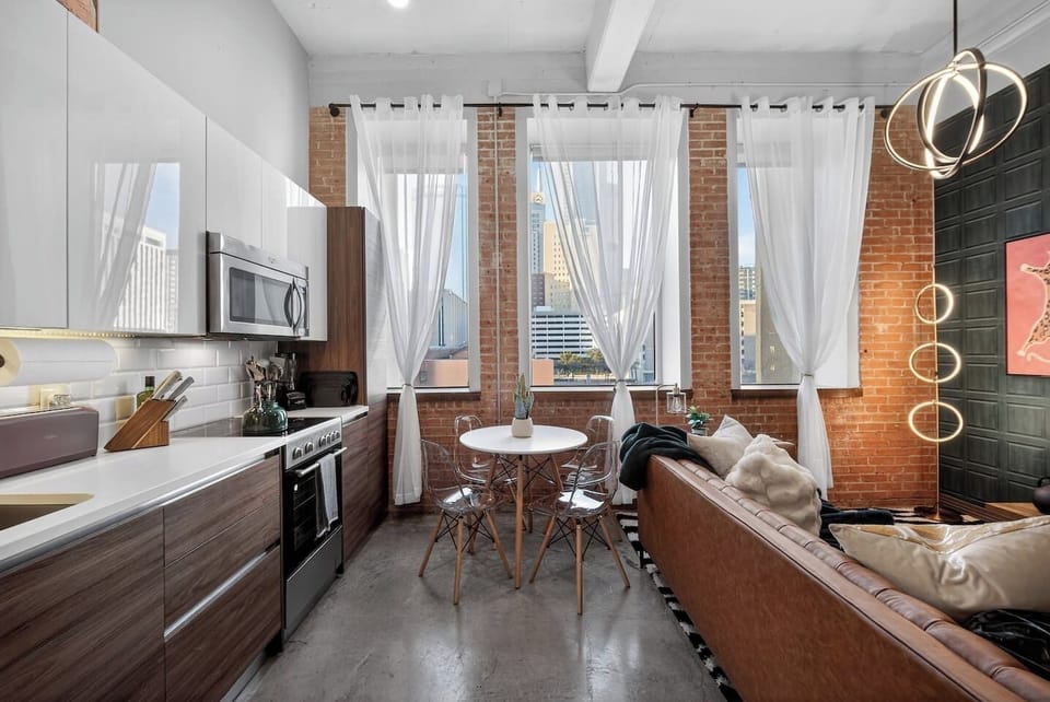 Kitchen & Dining Area: Bright, open-concept kitchen with modern appliances and sleek cabinetry, paired with a cozy dining nook by large windows—perfect for enjoying meals with a city view and natural light.