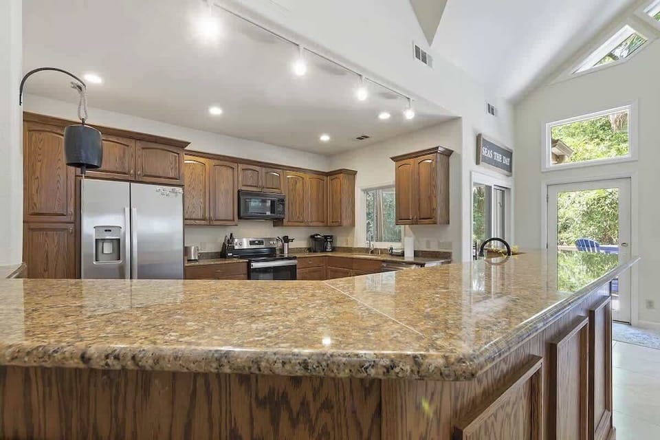Your spacious kitchen awaits with granite countertops, premium appliances, and abundant natural light streaming through windows.