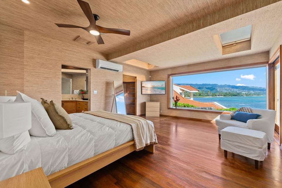 Wake up to stunning ocean views from your luxurious bedroom, where warm wood tones and crisp linens create your perfect retreat.