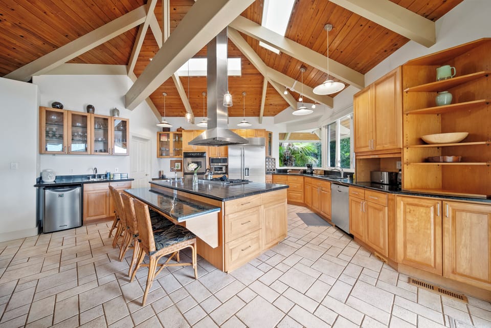 The spacious gourmet kitchen features vaulted wood ceilings, granite countertops, and premium appliances, perfect for creating memorable meals together.