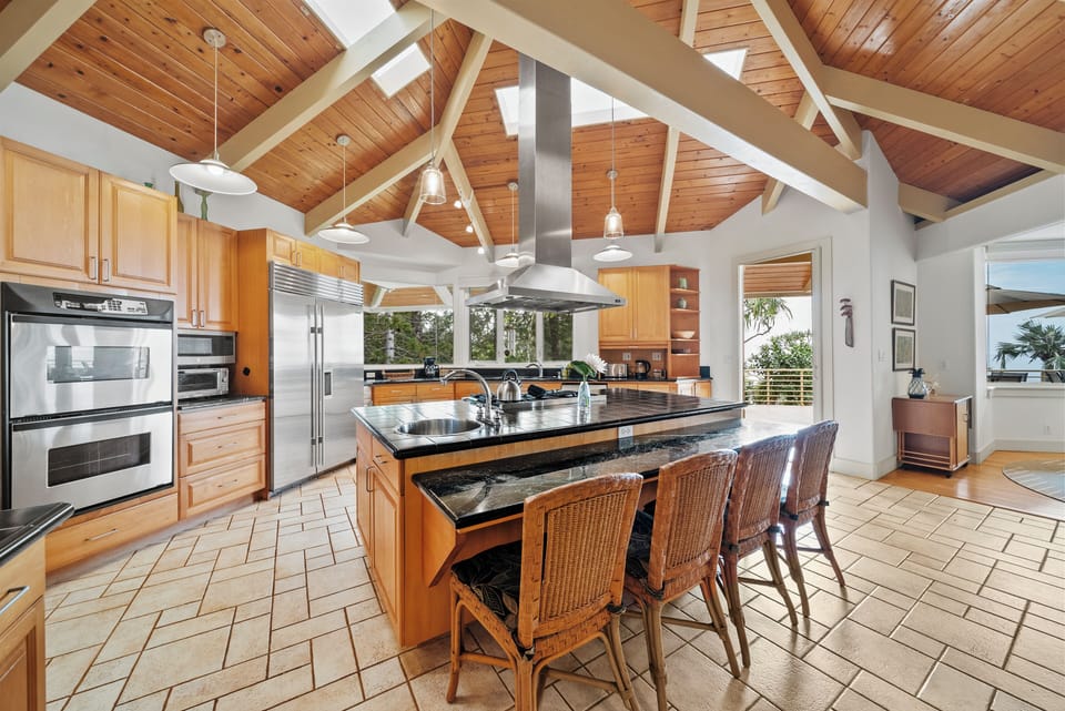 Your gourmet kitchen awaits with granite countertops, professional appliances, and vaulted wood ceilings creating the perfect space for memorable meal preparation.