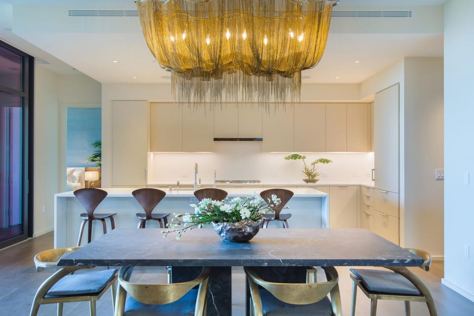Your elegant dining space features a stunning chandelier and sleek kitchen, perfect for memorable meals together.
