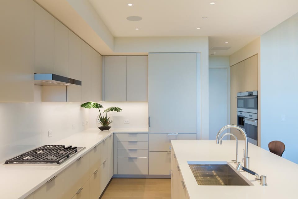 Your sleek modern kitchen features premium appliances, pristine white counters, and thoughtful design for effortless meal preparation.