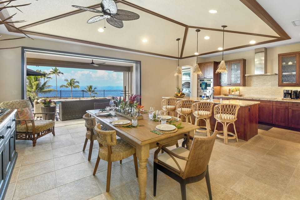 Savor meals in this stunning open-concept dining and kitchen space with breathtaking ocean views through expansive sliding glass doors.