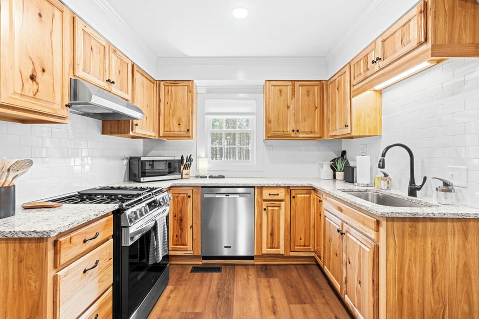 Kitchen contains gas range, dishwasher, and microwave/air fryer.