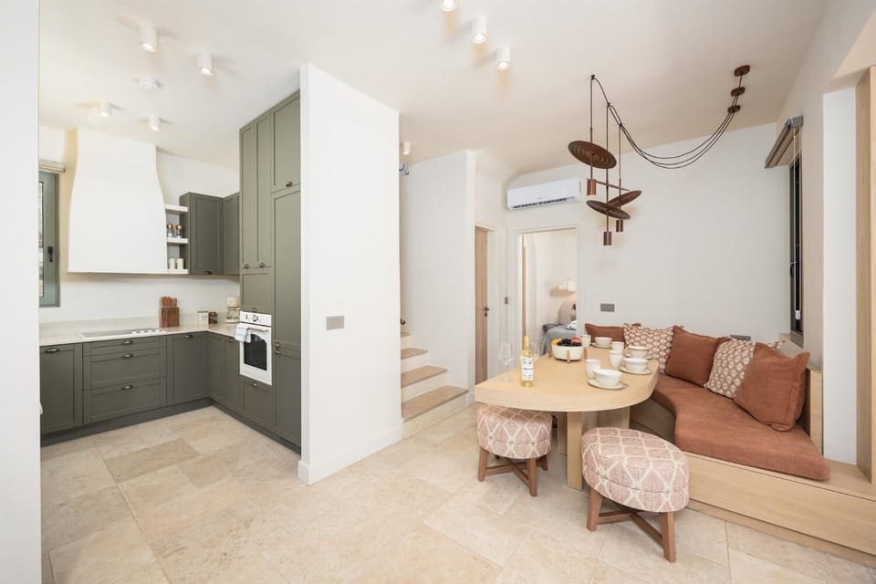 Open-plan living room with sofa, dining area, kitchen, A/C, WiFi internet, and satellite TV