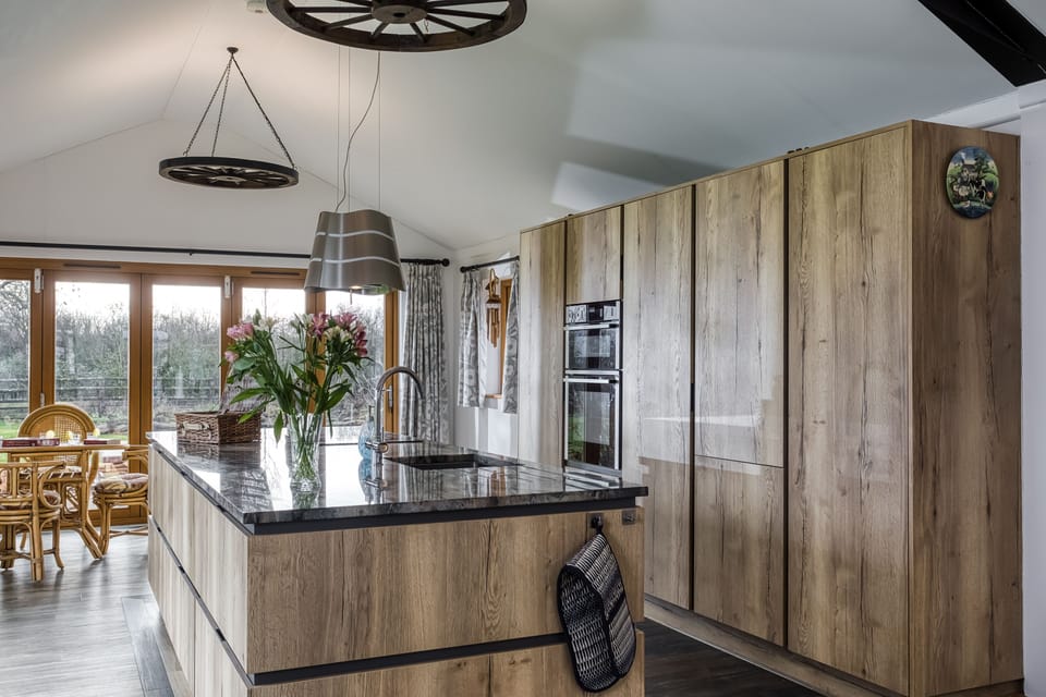 A wall of sleek kitchen units conceals various useful appliances