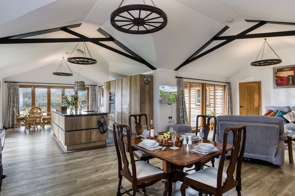 Owl Barn's vast open-plan L-shaped living area with vaulted ceilings and exposed beams