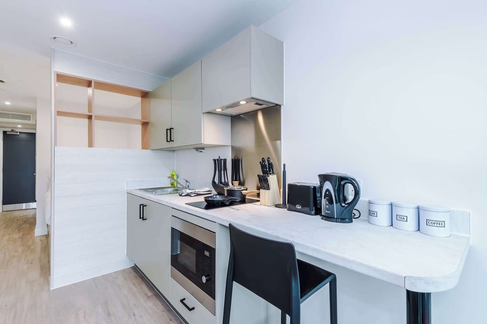 Compact studio kitchenette with workspace, ideal for contractors and long-stay guests.