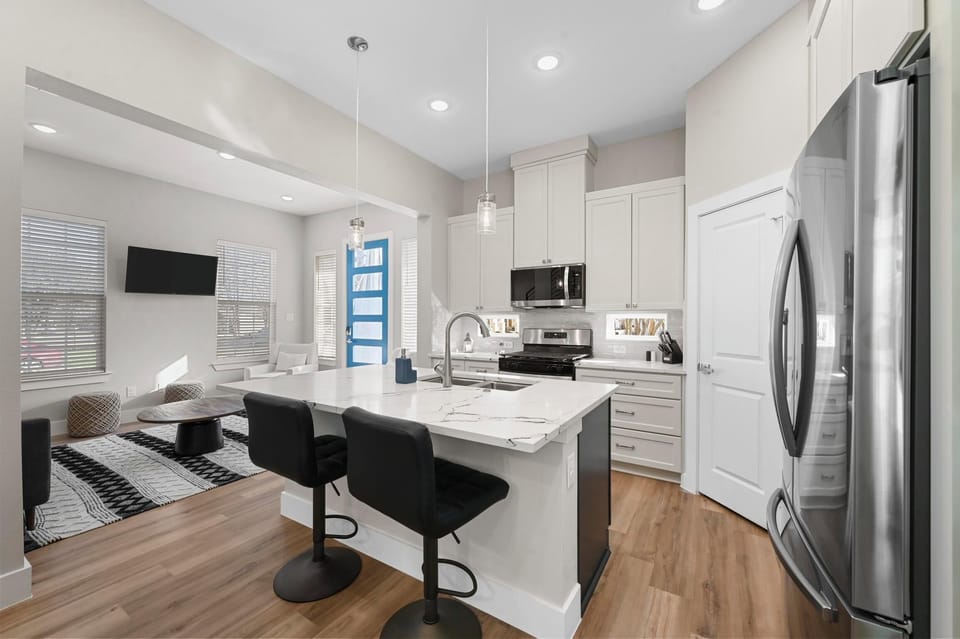 Fully stocked Kitchen with island and appliances overlooking dining and living .