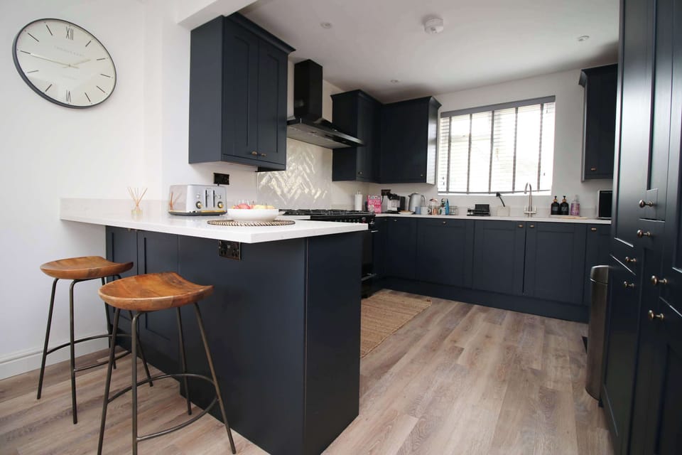 Modern kitchen with breakfast bar, sleek cabinetry and everything needed for home cooking.